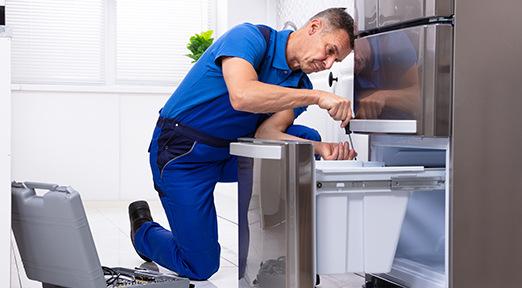 Repair technician fixing freezer drawer