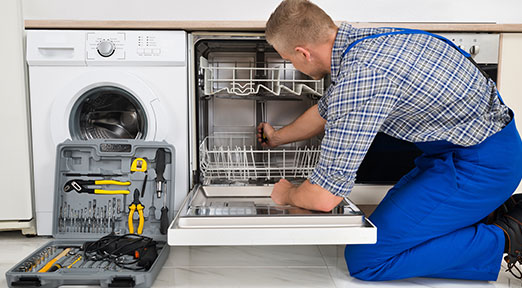 a technician repairs a dishwasher