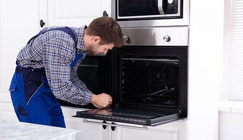 technician repairs an oven