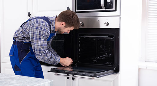 technician repairs an oven