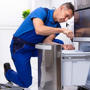 Repair technician fixing freezer drawer