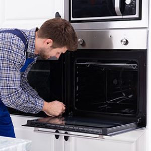 technician repairs an oven